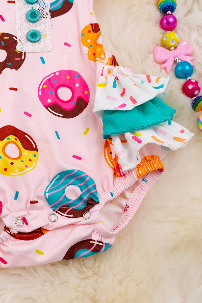 MULTI- PRINTED DONUT ON PINK BABY ONESIE.