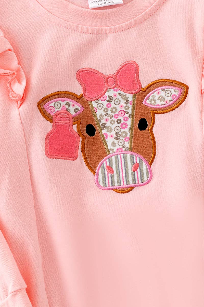Cow applique on pink sweatshirt with floral bell bottoms.